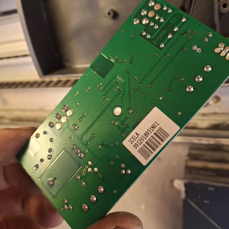 Scheda elettronica di una serranda smontata e tenuta in mano durante la riparazione